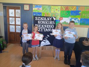  Dzieci trzymają  dyplomy i nagrody  książkowe