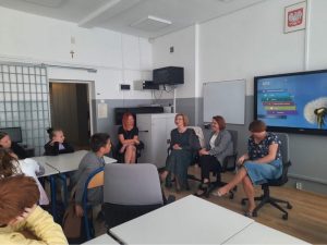Uczniowie klasy IV oraz nauczyciele w sali lekcyjnej podczas wspólnej rozmowy