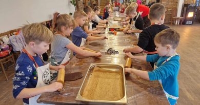 Uczniowie klasy pierwszej wałkują ciasto na pierniki.