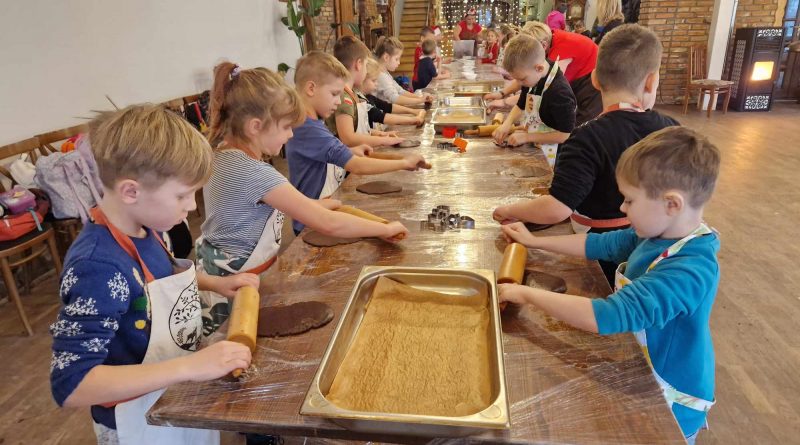 Uczniowie klasy pierwszej wałkują ciasto na pierniki.