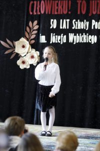 Uczennica klasy I na scenie podczas występu wokalnego