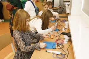 Uczniowie przy stoliku w sali przedstawiającej nowoczesne technologie - druk przy użyciu długopisów 3D