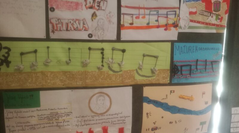 a parawanach rozwieszone są prace uczniów, Zapis nutowy - pierwsze cztery takty - "Mazurka Dąbrowskiego" przedstawione są za pomocą technik plastycznych, np. nuty zrobione są z pomponów, koralików, guzików, papiery. Poza tym wyeksponowane są kolaże inspirowane hymnem Polski. Oprócz tego zobaczyć można zapis dyktand na podstawie "Mazurka Dąbrowskiego".