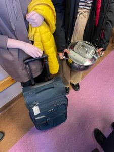 Uczniowie podczas przerwy na szkolnym korytarzu prezentują nosidła na książki i przybory szkolne w ramach akcji "Dzień bez plecaka"