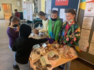 Grupa uczniów przy stoisku z ciastami
