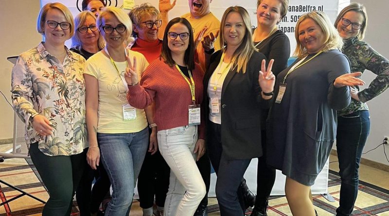 Zdjęcie grupowe nauczycielek z Gminy Czerwonak wraz z prowadzącym Szkolenie Dawidem Łsińskim. W tle baner z napisem "naszą supermocą jest uczenie"