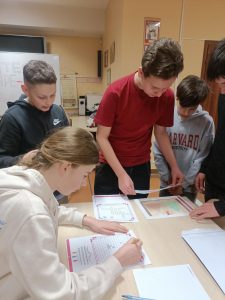 Uczniowie rozszyfrowują kod na skrzynce