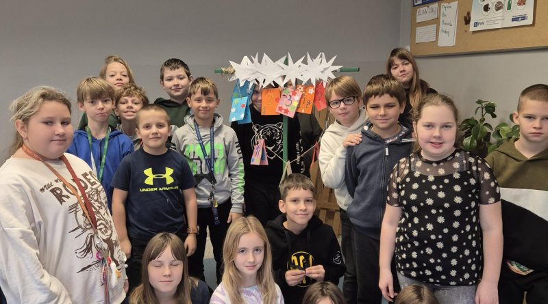 Uczniowie stoją przy ścianie. Prezentują kalendarz adwentowy.