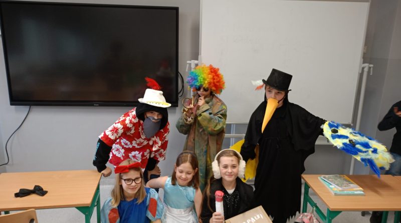 Na zdjęciach znajdują się dzieci przebrane w różnokolorowe stroje. Chłopiec ubrany jest w kwiecistą (białe i czerwone kwiaty) koszulę. Na głowie ma kapelusz i brodę z papieru. Drugie dziecko ubrane jest w kolorowy, długi płaszcz. Na głowie ma wielobarwną perukę. W ręce trzyma trąbkę. Nosi ciemne okulary. Chłopiec w ciemnym stroju. Dziób z papieru. Papierowe skrzydła. Dziewczynki w strojach księżniczek. Dziewczynka z wielkim pudłem zapałek i nienaturalnie dużą zapałką