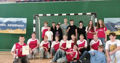 Zdjęcie 1: Na zdjęciu widzimy przedstawicieli drużyny SP Czerwonak ubranych w czerwone stroje sportowe ustawionych w szeregu przed bramką, pozujących z dyplomami oraz pucharem.