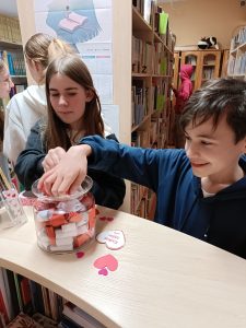 uśmiechnięty chłopiec losuje karteczkę ze słoja