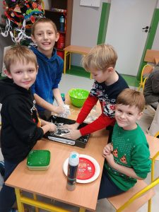 Czterech chłopców pozuje do zdjęcia. Uśmiechają się.