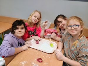 Cztery uśmiechnięte dziewczynki pozują do zdjęcia.