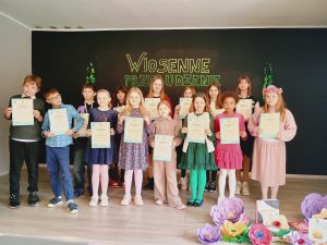 Na scenie stoją dzieci, które brały udział w konkursie. Każdy z nich trzyma w dłoniach dyplom.