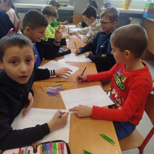 Uczniowie współpracując w parach, dzielą przy pomocy patyczków.