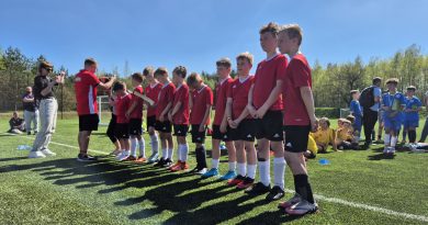 Chłopcy w czerwonych strojach w trakcie wręczania medali