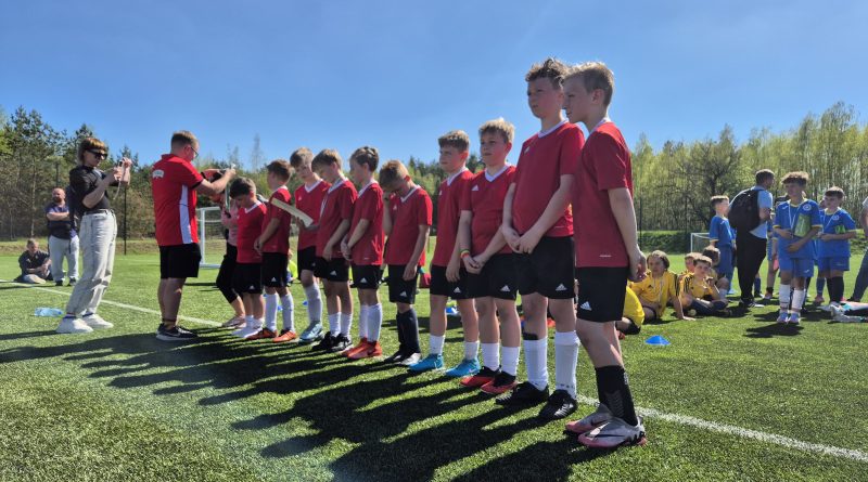 Chłopcy w czerwonych strojach w trakcie wręczania medali