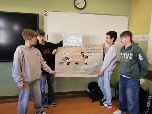 chłopcy z klasy 7a prezentują przygotowany przez siebie plakat.