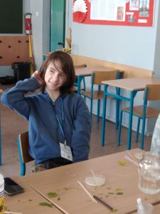 Zdjęcie 5

Na pierwszym planie uśmiechnięty uczeń, który wykonywał doświadczenie biologiczne z drożdżami. Na stole znajduję się szalka Petriego z drożdżami