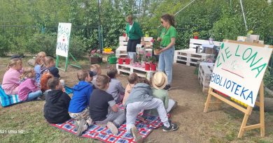 Stoisko Zielona Nauka, meble z palet , dzieci siedzą na kocach, pani pokazuje rośliny