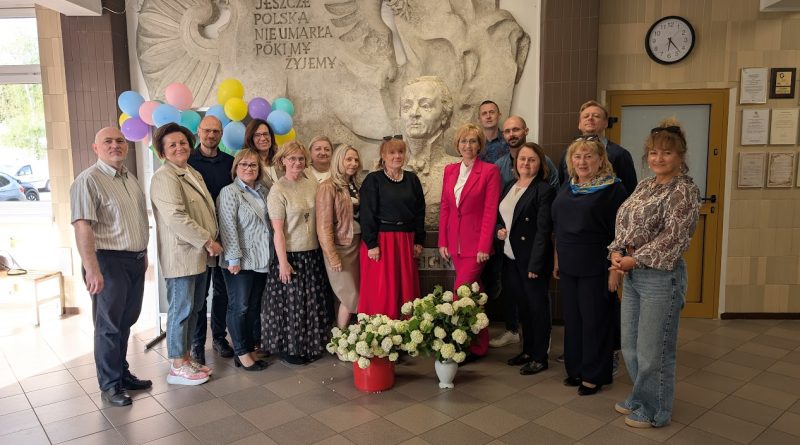 Wspólne zdjęcie uczestników innowacji w holu szkoły, na tle popiersia patrona szkoły Józefa Wybickiego