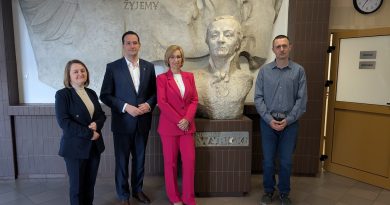 Wielkopolski Kurator Oświaty wraz z dyrekcją szkoły stoją na holu obok popiersia patrona szkoły, Józefa Wybickiego