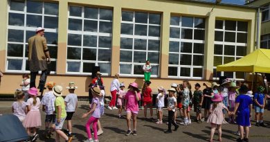 Parada uczniów z ozdobionymi głowami z Panem Kapelusznikiem na czele.