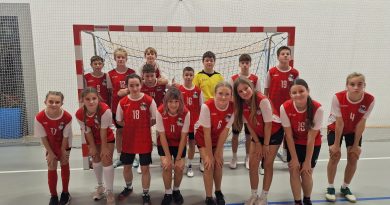 Zdjęcie grupowe dziewczat i chłopców w strojach sportowych na tle bramki