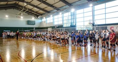 Przedstawia otwarcie zawodów. Widać na nim ustawione zawodniczki ubrane w kolorowe stroje sportowe. Przemawia Dyrektor Szkoły Podstawowej w Czerwonaku Pani Magdalena Zielenkiewicz. Dzieje się to na hali AKWEN w Czerwonaku. Wszyscy stoją na parkiecie a za plecami mają ustawioną siatkę oraz boiska do gry w minisiatkówkę.