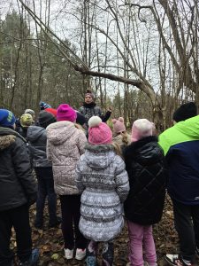 uczniowie w lesie słuchają przewodnika