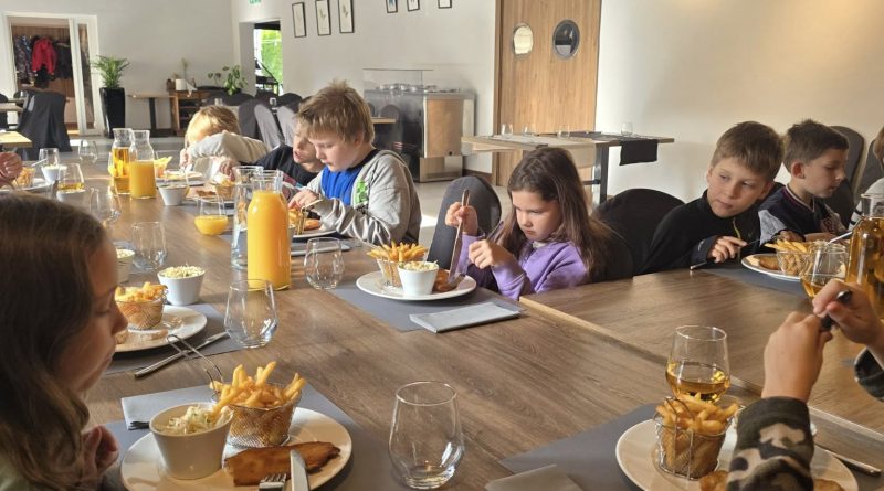 dzieci jedzą przy stole w restauracji