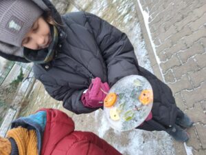 Uczniowie wyjmują z pojemników zamrożone lodowe rzeźby.