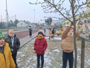 Uczniowie wyjmują z pojemników zamrożone lodowe rzeźby.