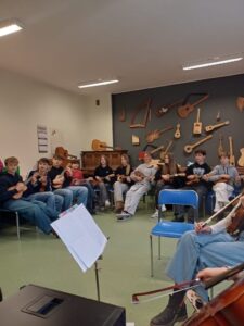 Występ zespołu wokalno-instrumentalnego – uczniowie w sali lekcyjnej.