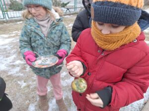Uczniowie wyjmują z pojemników zamrożone lodowe rzeźby.