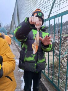 Uczniowie wyjmują z pojemników zamrożone lodowe rzeźby.