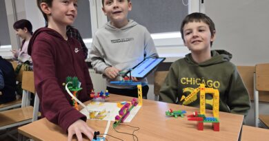 3 uśmiechniętych chłopców prezentuje konstrukcję.