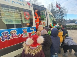 Uczniowie oglądają smoczy ambulans i zapoznają się z jego wyposażeniem.