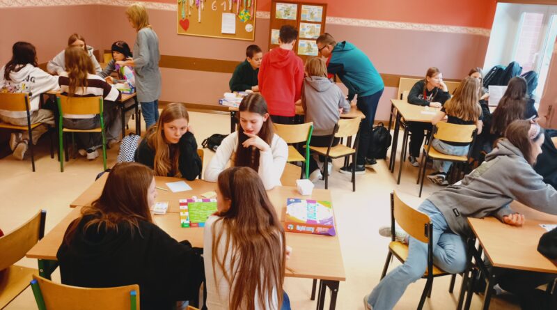 Połączone po cztery ławki stoliki tworzą zespoły, przy których uczniowie wspólnie grają w gry edukacyjne, współpracując i poszukując poprawnych odpowied