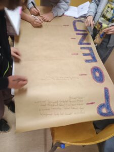 Uczniowie tworzą plakat o poezji.