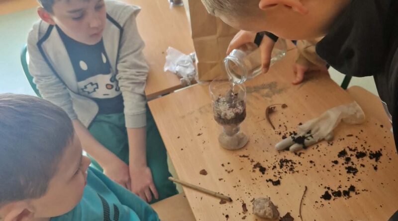 chłopcy konstruują filtr z piasku