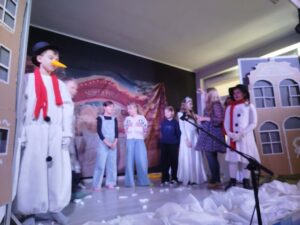 Aktorzy stoją na scenie w trakcie przedstawienia.