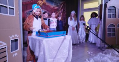 Aktorzy stoją na scenie w trakcie przedstawienia.