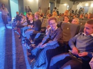 uczniowie w teatrze, na widowni oraz aktorami występującymi w spektaklu.