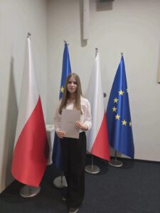 Zdjęcie 3 – Dominika Kaczmarczyk z zaświadczeniem Laureatki Wojewódzkiego Konkursu Chemicznego i Laureatki Wojewódzkiego Konkursu Fizycznego